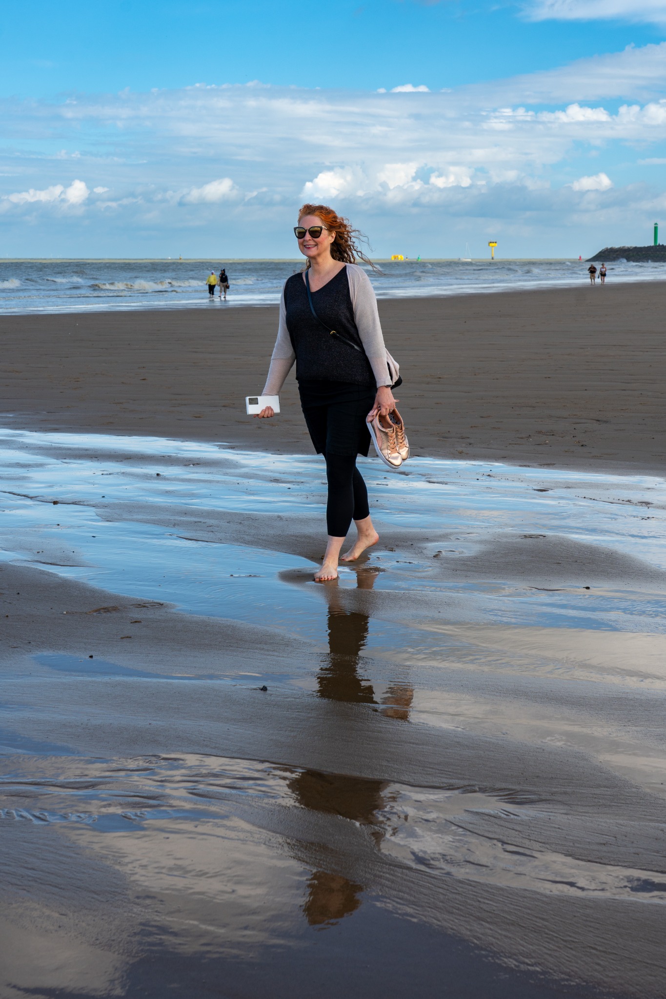 Woman walking barefoot on the beach in Ostend, Belgium