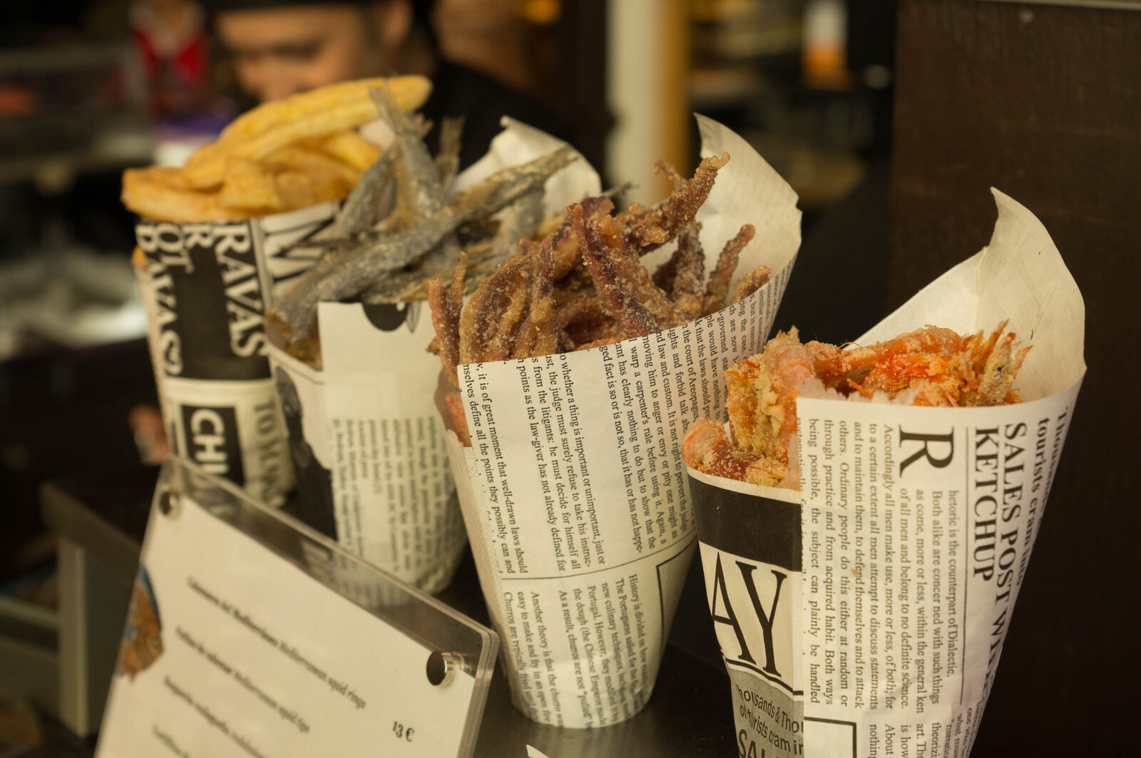 Paper cones of fried anchovies, prawns and chips at a Madrid tapas bar